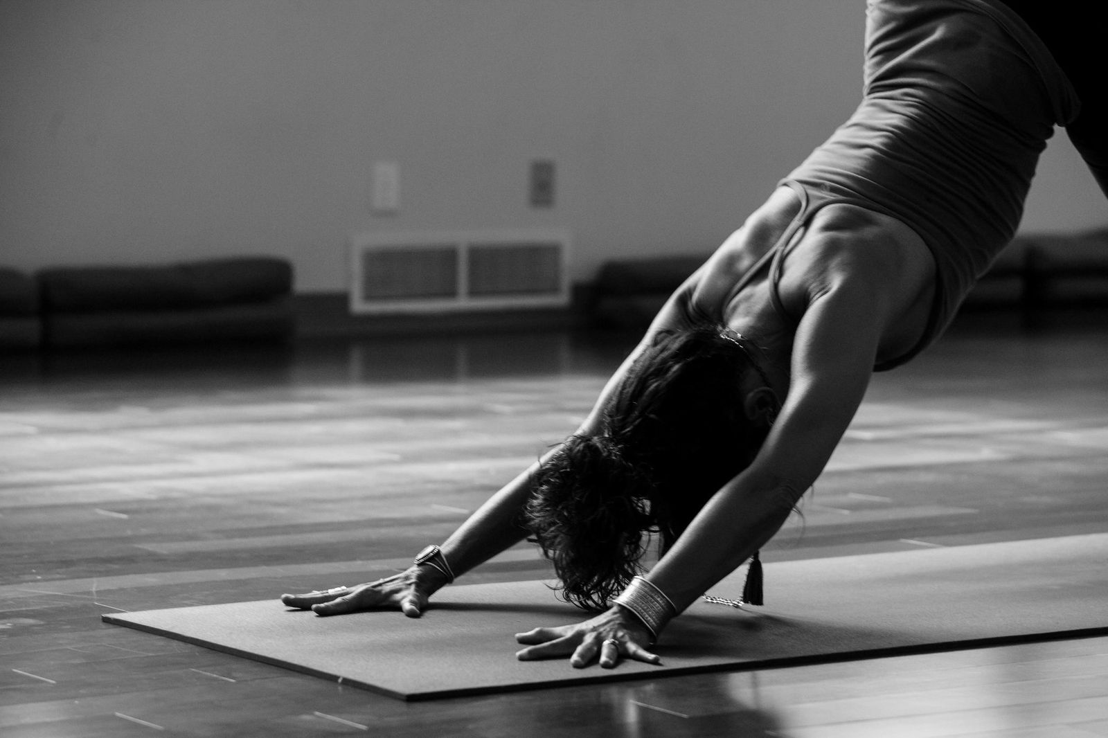 Woman in downward dog yoga pose, black and white, showing focus and presence