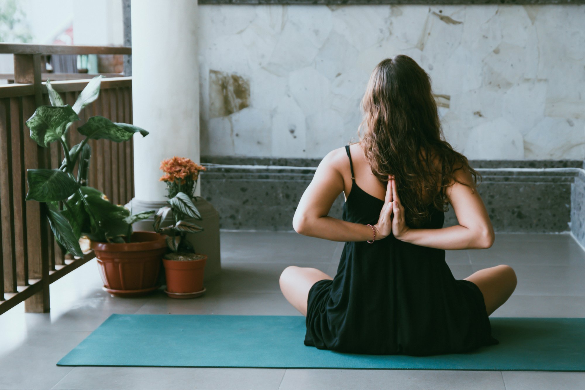 Woman practicing yin yoga for beginners, sitting cross-legged with hands in reverse prayer
