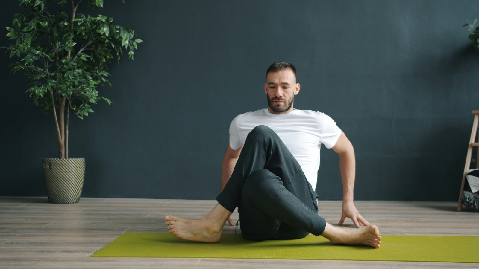 Beginner yin yoga seated twist pose, eyes closed, relaxed and present